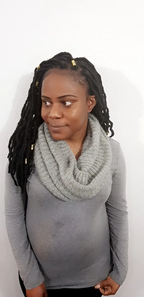 A client showing loose shoulder-length locs finished with gold cuffs