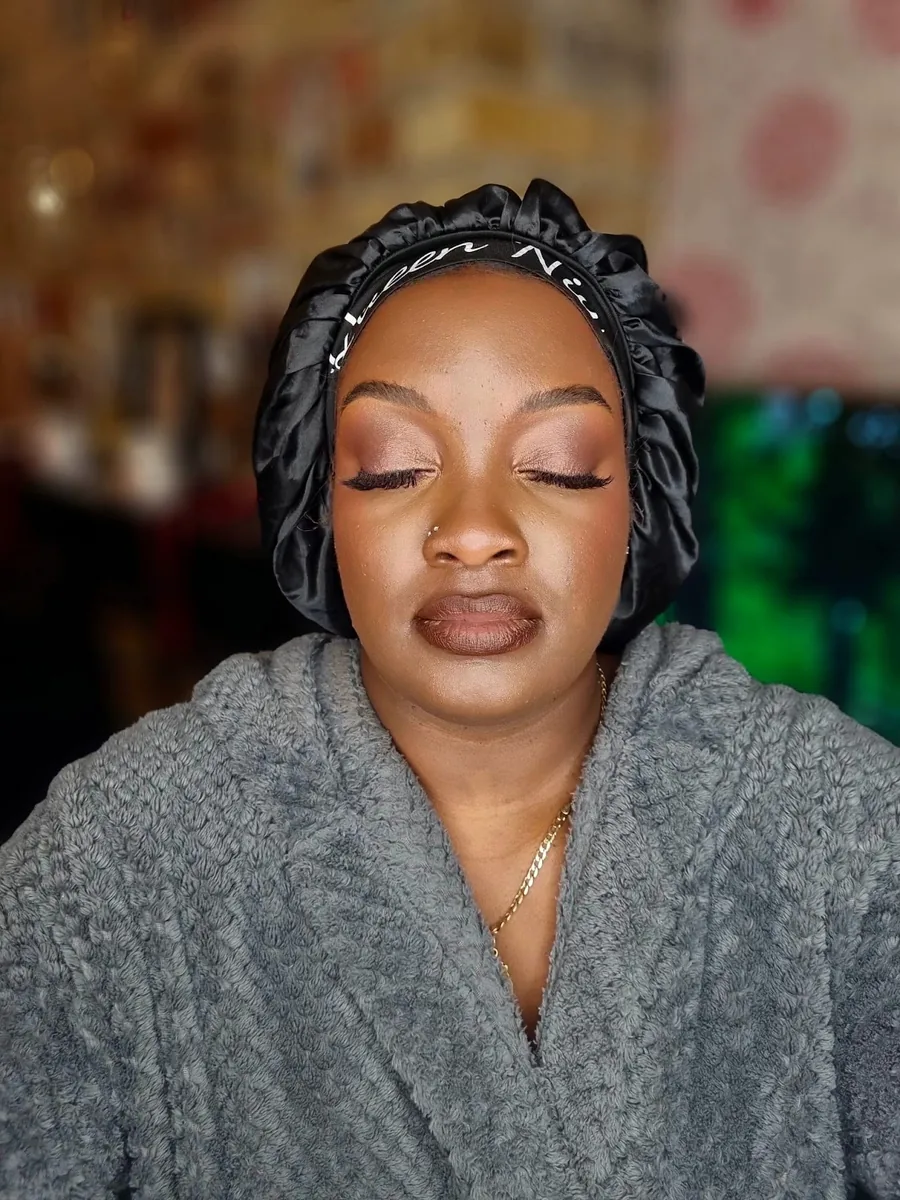 Close-up of a client with eyes closed showing finished soft-glam eye make-up, lashes and lined lip